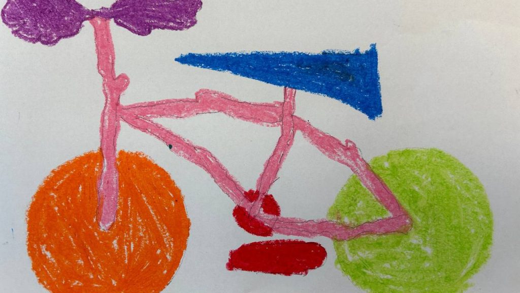 Colorful crayon drawing of a bicycle with orange and green wheels, a pink frame, a blue seat, red pedals, and a purple handlebar.
