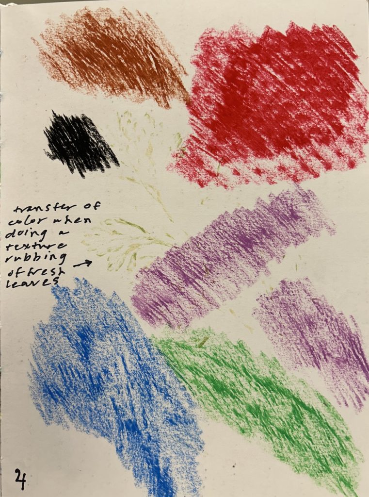 A sketchbook page features a colorful texture rubbing made with oil pastels in shades of red, brown, black, blue, green, and purple. Imprints of fresh leaves are faintly visible beneath the rubbings, and a handwritten note reads: “transfer of color when doing a texture rubbing of fresh leaves.”